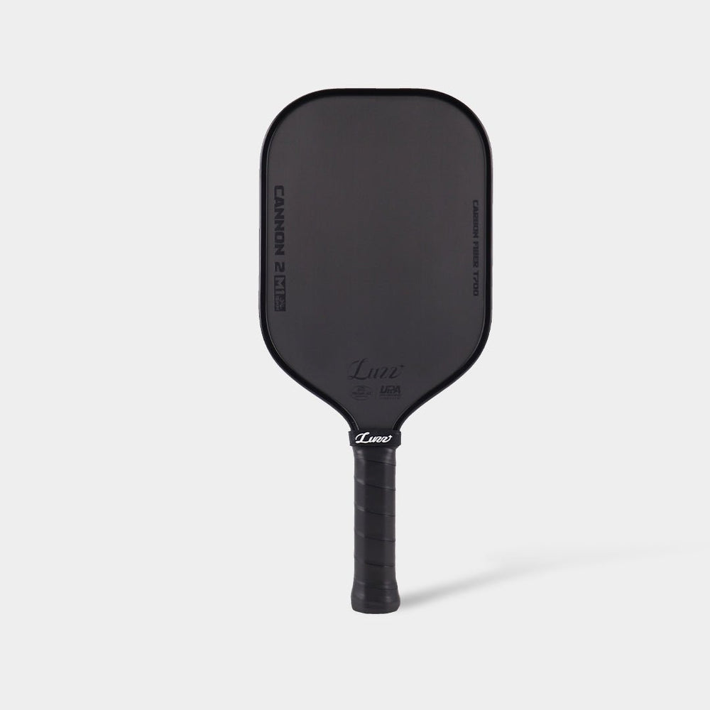 LUZZ CANNON2 M1 Paddle front view featuring an all-black design with a matte black face, gloss black LUZZ logo and UPA-A and USAP certification logos at the bottom, and glossy black side edges