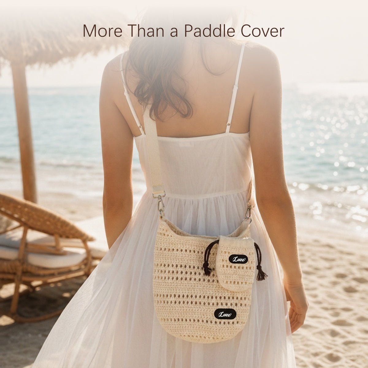 Model in white dress wearing a crossbody open-knit pickleball paddle cover at the beach