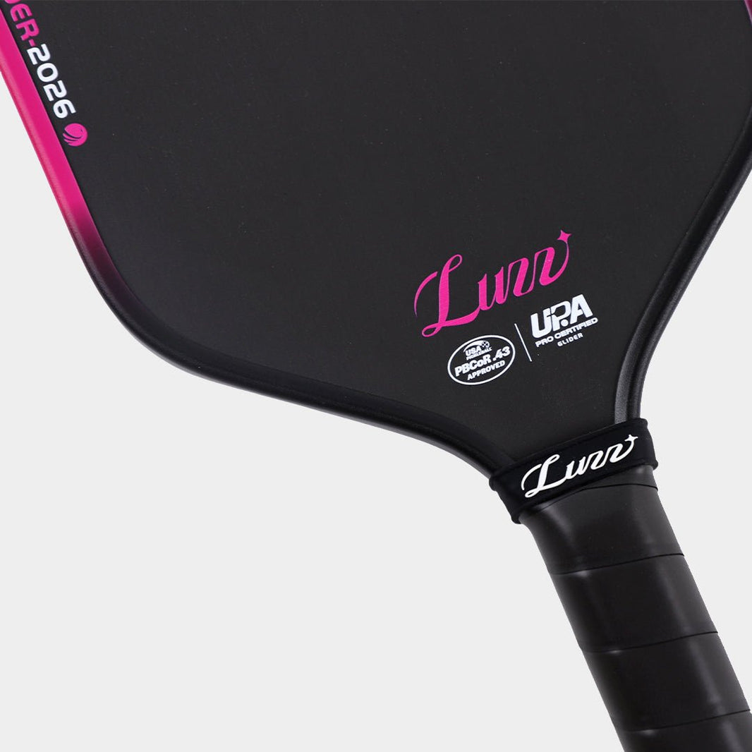 Close-up detail of the LUZZ Glider 2026 Hybrid Paddle face featuring a pink LUZZ logo and white UPA-A and USAP certification logos at the bottom