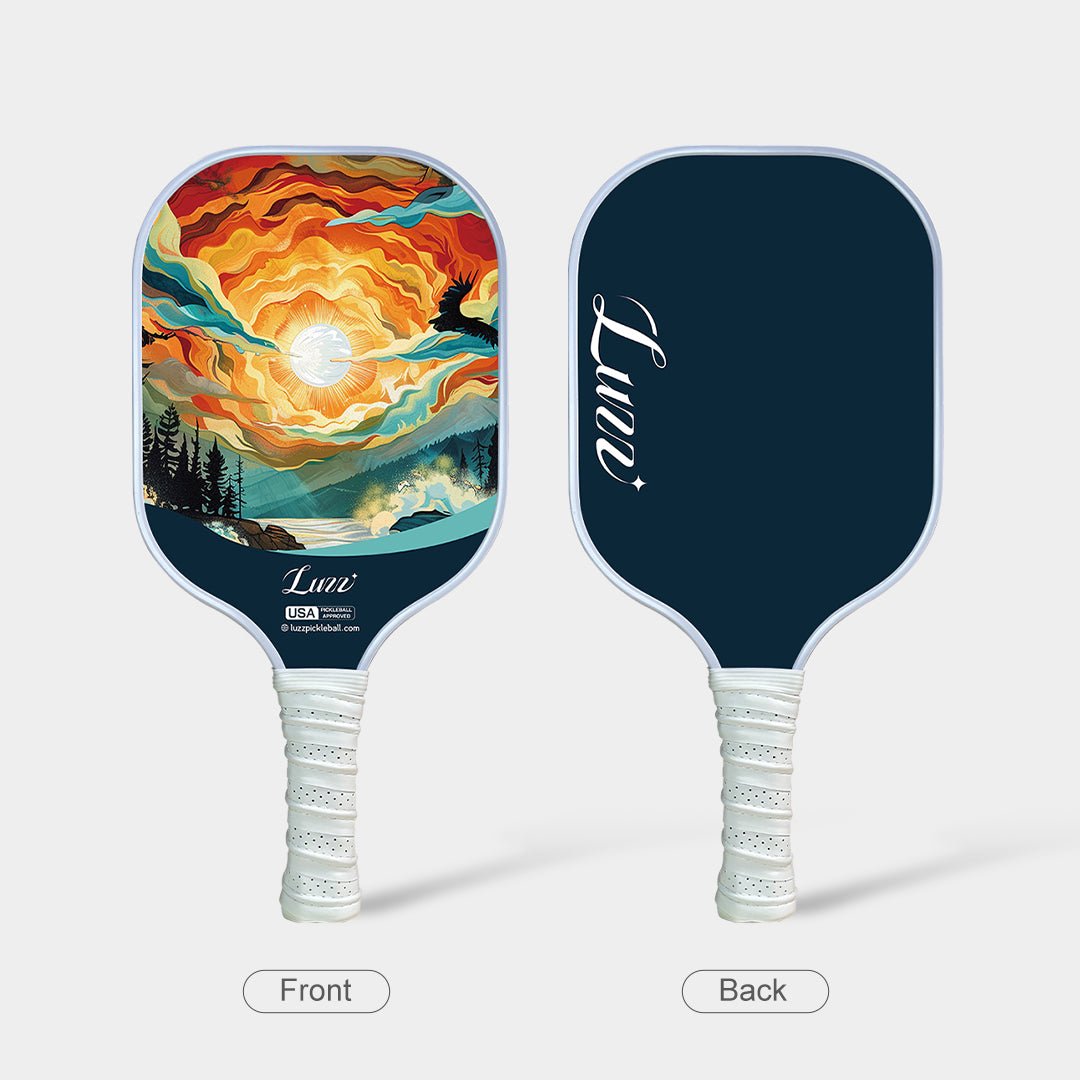 Front and back view of the paddle, featuring an oil-painting-style sunset landscape on the front face, a navy blue back face, and a white handle.