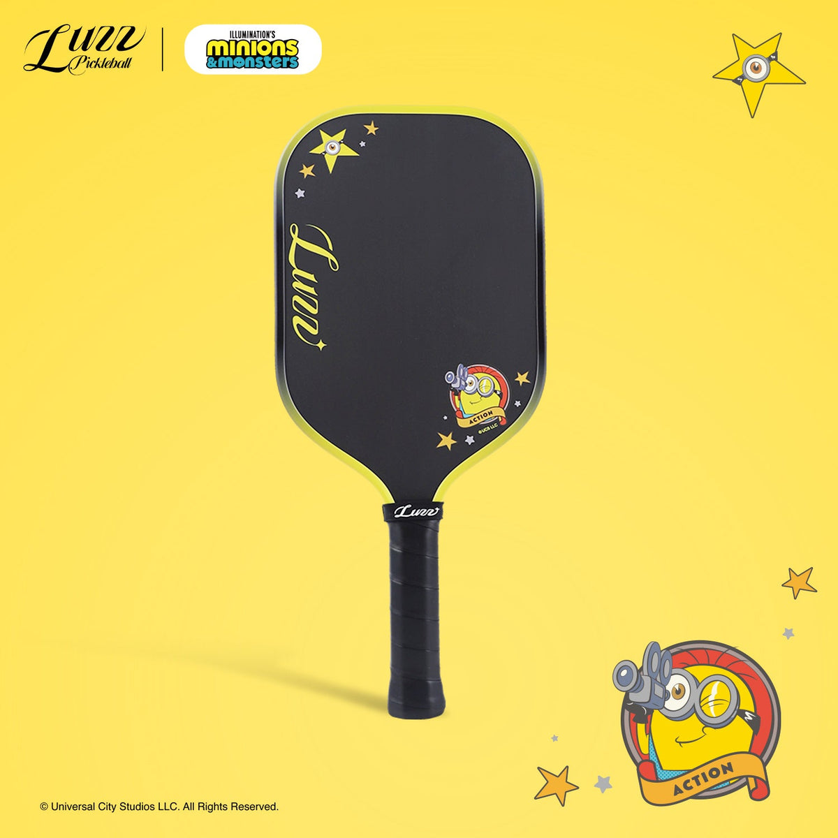 Front view of the opposite side of the pickleball paddle on a yellow background, featuring a Minions graphic and LUZZ logo on the black paddle face