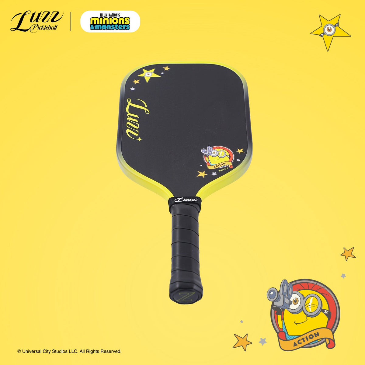 Perspective view of a pickleball paddle on a yellow background, featuring Minions graphic and LUZZ logo on a black paddle face
