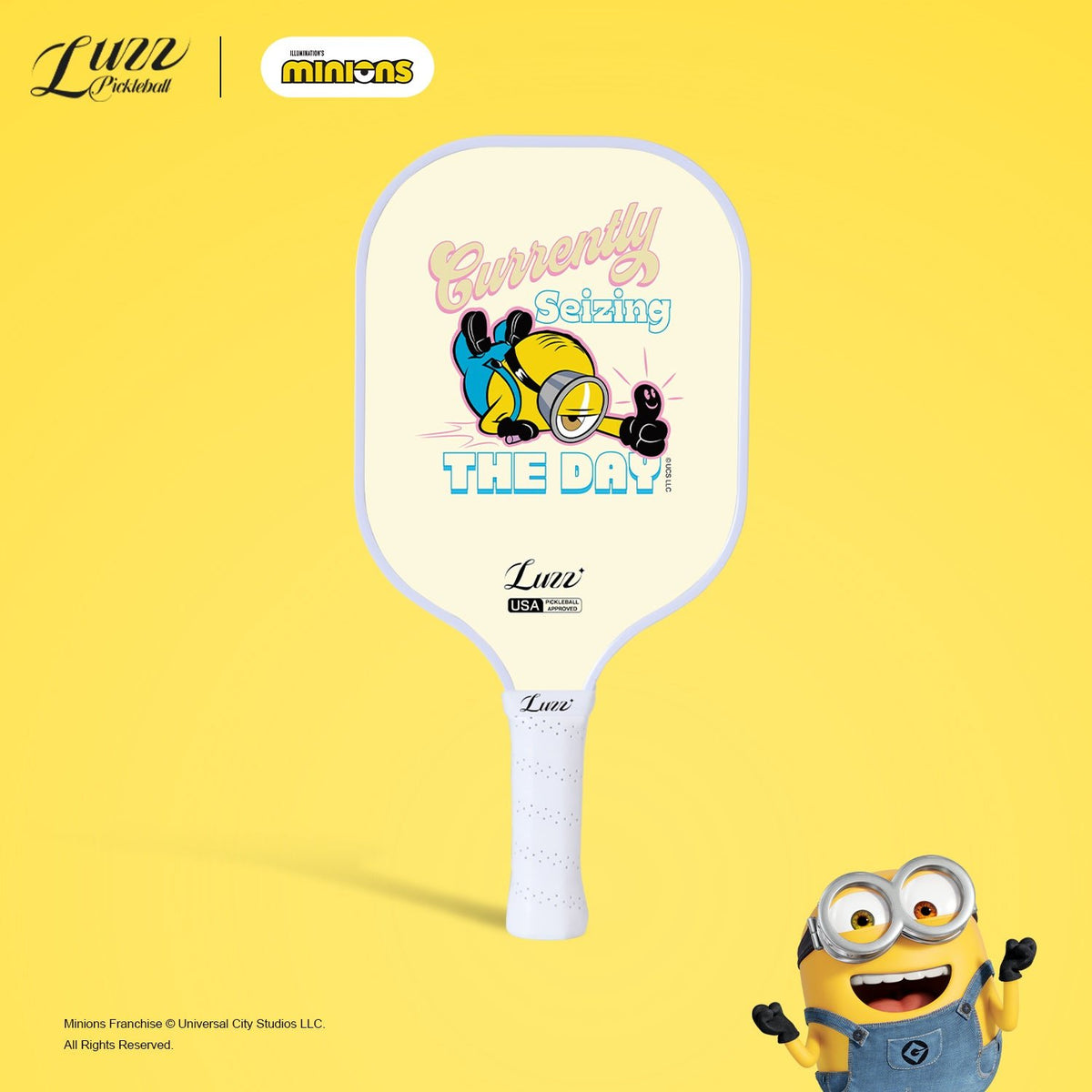 Minions collaboration Carpe Diem pickleball paddle front view featuring a cream yellow paddle face with Minions graphics and artistic lettering
