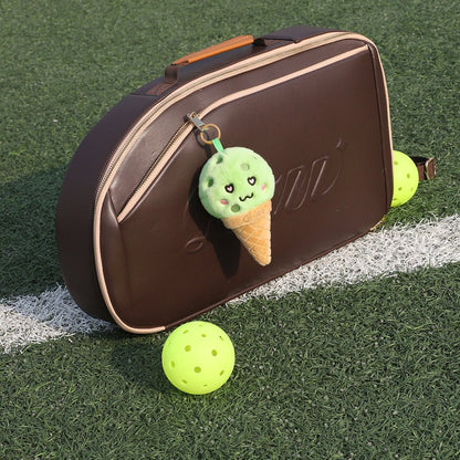 LUZZ Heart-Eyes Ice Cream Plush Charm hanging from a brown pickleball bag