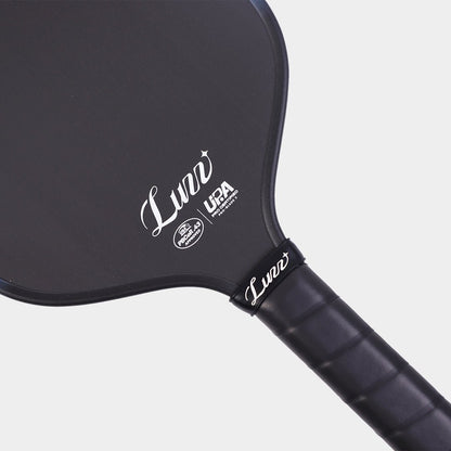 Close-up detail of the LUZZ ProBladz 2 paddle face and handle connection, featuring a white LUZZ logo and UPA-A and USAP certification logos at the bottom of the paddle face