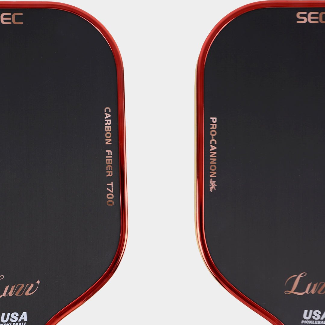 Close-up detail of a black pickleball paddle face featuring “CARBON FIBER T700” on one side, “PRO-CANNON” on the other, and a red paddle edge