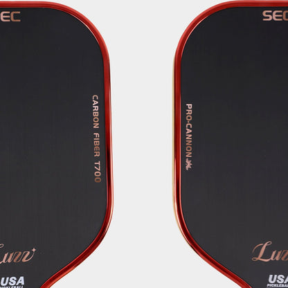 Close-up detail of a black pickleball paddle face featuring “CARBON FIBER T700” on one side, “PRO-CANNON” on the other, and a red paddle edge